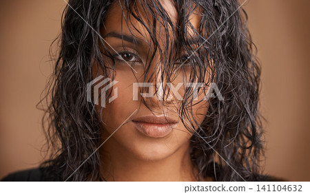 Wet hair, portrait and Indian woman in studio for beauty, wellness or shine cosmetics on brown background. Haircare, cleaning or calm female model face with shampoo, results or scalp detox treatment Wet hair, portrait and Indian woman in studio for beauty, wellness or shine cosmetics on brown background. Haircare, cleaning or calm female model face with shampoo, results or scalp detox treatment 141104632