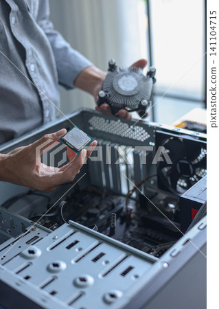 Computer engineer repair and assembling high-performance PC, CPU and cooler at workshop desk. Computer engineer repair and assembling high-performance PC, CPU and cooler at workshop desk. 141104715