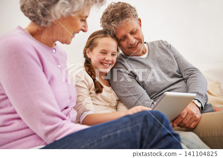 Tablet, grandma and grandpa with girl in house, senior and woman babysitting granddaughter. Living room, old man and female person with internet for growth and development of child with movies Tablet, grandma and grandpa with girl in house, senior and woman babysitting granddaughter. Living room, old man and female person with internet for growth and development of child with movies 141104825