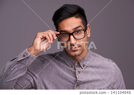 Young man, face and glasses in studio for eye care, vision and new frame with confidence on a gray background. Portrait of a young person or cool model in spectacles, eyewear and vision or lens check Young man, face and glasses in studio for eye care, vision and new frame with confidence on a gray background. Portrait of a young person or cool model in spectacles, eyewear and vision or lens check 141104848