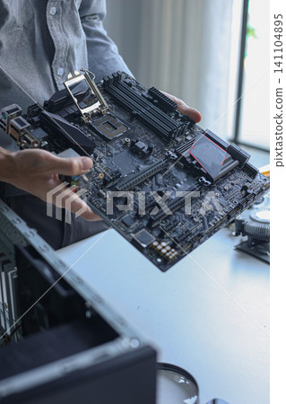 Computer engineer repairing computer motherboard and hardware components. Computer engineer repairing computer motherboard and hardware components. 141104895