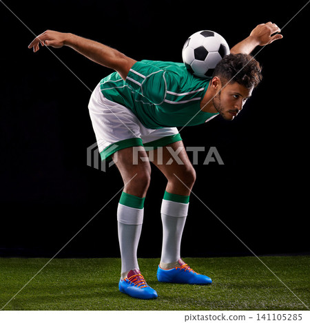 Man, ball and soccer for balance, sport and match for fitness, game and active for sportswear on grass or field. Arab person, role model or athlete and practice for competitive on dark background 141105285