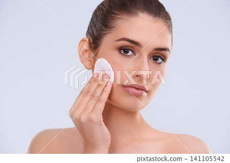 Portrait, woman and cotton pad for makeup removal from skin, cosmetics and beauty product on white background. Skincare routine, cleanse and wipe face, dermatology and facial treatment in studio Portrait, woman and cotton pad for makeup removal from skin, cosmetics and beauty product on white background. Skincare routine, cleanse and wipe face, dermatology and facial treatment in studio 141105542