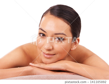Health, portrait and woman at spa for massage with skincare, wellness or body treatment in studio. Happy, smile and face of Asian female person on table for relaxing routine by white background. Health, portrait and woman at spa for massage with skincare, wellness or body treatment in studio. Happy, smile and face of Asian female person on table for relaxing routine by white background. 141105892