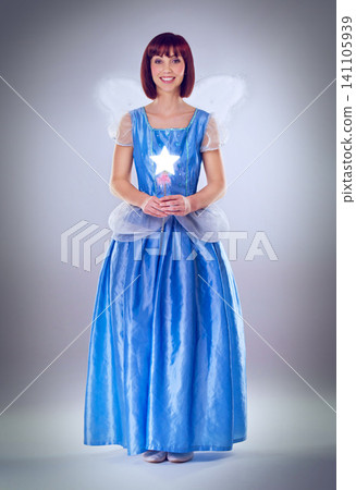 Woman, fairy godmother and smile in studio portrait with wand, wings and dress for magic by background. Person, fantasy and star with glow, shine and happy with power, wish and surreal fairytale Woman, fairy godmother and smile in studio portrait with wand, wings and dress for magic by background. Person, fantasy and star with glow, shine and happy with power, wish and surreal fairytale 141105939