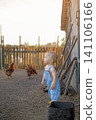 Toddler at a poultry farm. Childhood in the countryside. A boy watching chickens 141106166