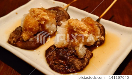 Grilled shiitake mushrooms on charcoal, served with plenty of grated daikon radish. Grilled shiitake mushrooms on charcoal, served with plenty of grated daikon radish. 141107040