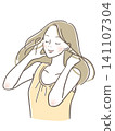 Woman brushing her hair with a smile 141107304