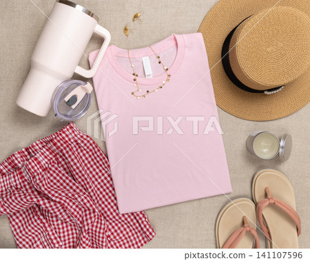 Blank light pink folded shirt mockup with woman summer accessories, template for print on demand Blank light pink folded shirt mockup with woman summer accessories, template for print on demand 141107596