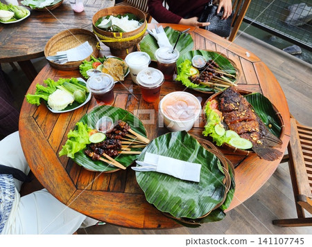 Sundanese traditional food serving on a wooden table. Sundanese traditional food serving on a wooden table. 141107745
