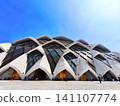 Majestic facade of Al Jabbar Mosque with a curved roof. 141107774