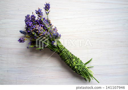 Fresh lavender bouquet tied with green twine on pale wooden surface, rustic floral still life Fresh lavender bouquet tied with green twine on pale wooden surface, rustic floral still life 141107946