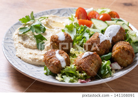 Falafel with hummus and fresh salad on wooden table Falafel with hummus and fresh salad on wooden table 141108091