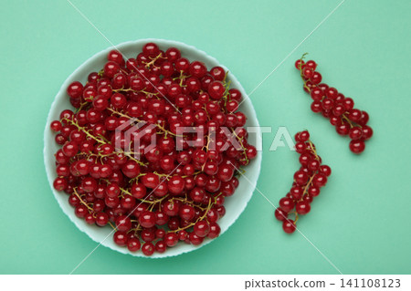 Red currants on blue plate on mint background. Fresh and vibrant food photography for healthy eating. Space for text 141108123
