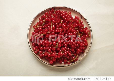Red currants on plate on light grey background. Fresh and vibrant food photography for healthy eating. Red currants on plate on light grey background. Fresh and vibrant food photography for healthy eating. 141108142