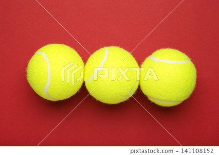 Bright yellow tennis balls on red background Bright yellow tennis balls on red background 141108152