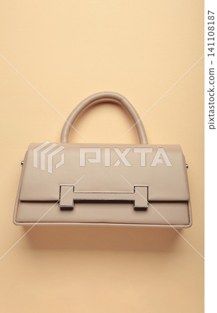 Beige female bag on beige background. Vertical photo Beige female bag on beige background. Vertical photo 141108187