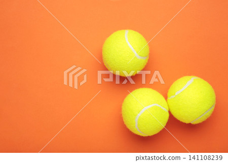 Bright yellow tennis balls on orange background Bright yellow tennis balls on orange background 141108239