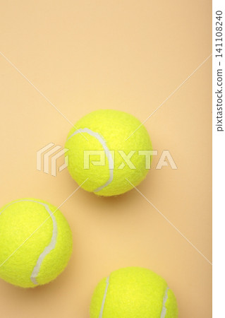 Bright yellow tennis balls on beige background. Vertical photo Bright yellow tennis balls on beige background. Vertical photo 141108240