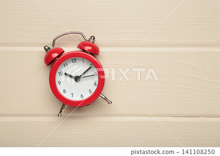 Classic red alarm clock on light wooden background. Classic red alarm clock on light wooden background. 141108250