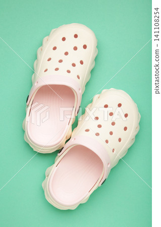 Mykolaiv, Ukraine - April 25, 2026: Couple of white Crocs sandals on mint background. Vertical photo Mykolaiv, Ukraine - April 25, 2026: Couple of white Crocs sandals on mint background. Vertical photo 141108254