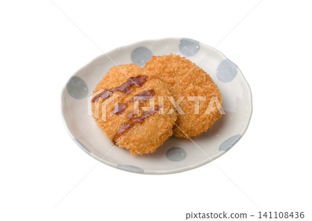 Two croquettes placed on a plate and covered in sauce. Two croquettes placed on a plate and covered in sauce. 141108436