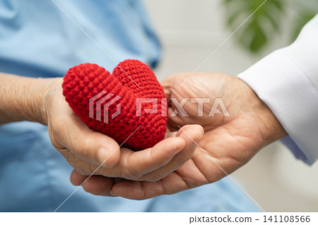 Asian elder senior woman patient holding red hear and give to doctor t in hospital. Asian elder senior woman patient holding red hear and give to doctor t in hospital. 141108566