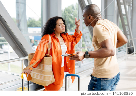 Frustrated young black woman arguing with partner at airport Frustrated young black woman arguing with partner at airport 141108850