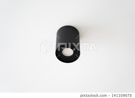 Black ceiling light fixture illuminating modern minimalist interior design, contemporary cylindrical spotlight on white background Black ceiling light fixture illuminating modern minimalist interior design, contemporary cylindrical spotlight on white background 141109078