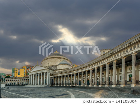 Naples, italy. December 27, 2024. San francesco di paola church and colonnade at piazza del plebiscito in naples, italy, with dramatic sunbeams piercing cloudy sky Naples, italy. December 27, 2024. San francesco di paola church and colonnade at piazza del plebiscito in naples, italy, with dramatic sunbeams piercing cloudy sky 141109304