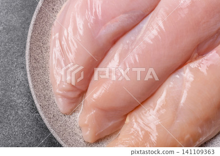 Fresh raw chicken fillet with salt and spices for home cooking. Raw chicken fillet Fresh raw chicken fillet with salt and spices for home cooking. Raw chicken fillet 141109363
