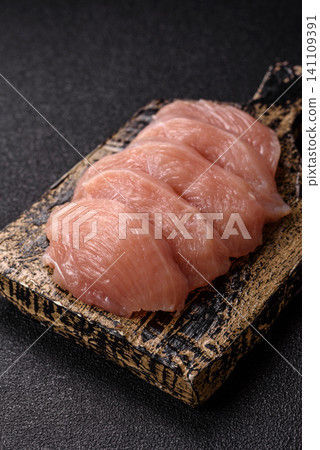 Fresh raw chicken fillet with salt and spices for home cooking. Raw chicken fillet Fresh raw chicken fillet with salt and spices for home cooking. Raw chicken fillet 141109391