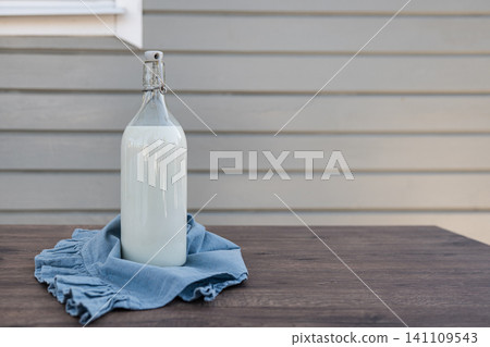 Glass bottle of milk on table with copy space Glass bottle of milk on table with copy space 141109543