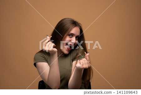 Young woman making a Korean finger heart gesture with both hands, expressing sincere love and care Young woman making a Korean finger heart gesture with both hands, expressing sincere love and care 141109643