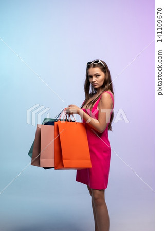 Young woman shopper holding many colorful paper bags after shopping trip, enjoying retail therapy and sales Young woman shopper holding many colorful paper bags after shopping trip, enjoying retail therapy and sales 141109670