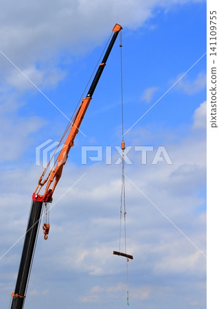 Image of a crane lifting reinforcing bars. Image of a crane lifting reinforcing bars. 141109755