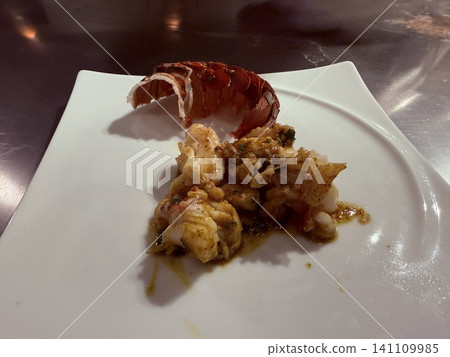 Grilled spiny lobster elegantly presented on a white plate. Grilled spiny lobster elegantly presented on a white plate. 141109985