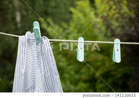 Laundry hanging on clothesline outdoor eco washing and sustainable home lifestyle concept 141110013