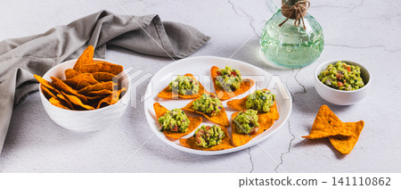 Mexican food avocado guacamole with nachos on a plate on the table web banner Mexican food avocado guacamole with nachos on a plate on the table web banner 141110862