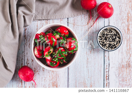 Delicious appetizer of smashed pickled radishes with herbs in a bowl on the table top view Delicious appetizer of smashed pickled radishes with herbs in a bowl on the table top view 141110867