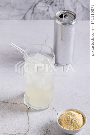 Carbonated protein drink in a glass and a can on the table vertical view Carbonated protein drink in a glass and a can on the table vertical view 141110875