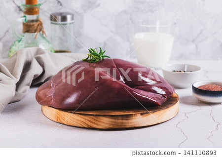 Raw whole pork liver on a wooden board on the table Raw whole pork liver on a wooden board on the table 141110893