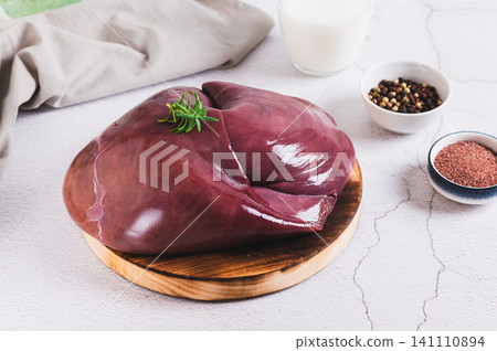 Fresh beef liver on a cutting board on the table Fresh beef liver on a cutting board on the table 141110894