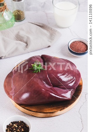 Fresh beef liver on a cutting board on the table vertical view Fresh beef liver on a cutting board on the table vertical view 141110896
