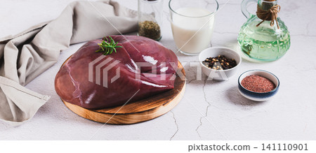 Fresh beef liver on a cutting board on the table web banner Fresh beef liver on a cutting board on the table web banner 141110901