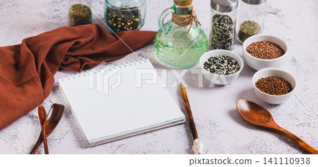 A notebook and pen for writing down recipes, spoons and spices on the kitchen table web banner A notebook and pen for writing down recipes, spoons and spices on the kitchen table web banner 141110938