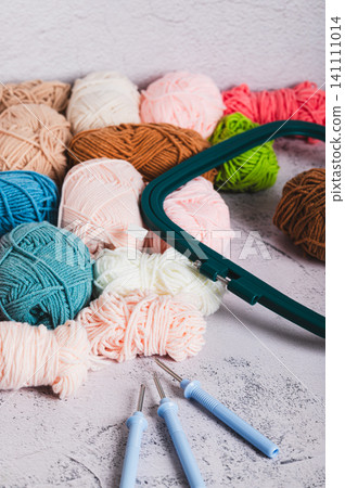 A set of colored yarn and tools for carpet embroidery on a table vertical view A set of colored yarn and tools for carpet embroidery on a table vertical view 141111014