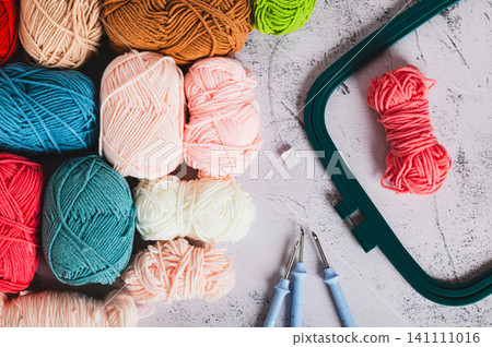 A set of colored yarn and tools for carpet embroidery on a table top view A set of colored yarn and tools for carpet embroidery on a table top view 141111016