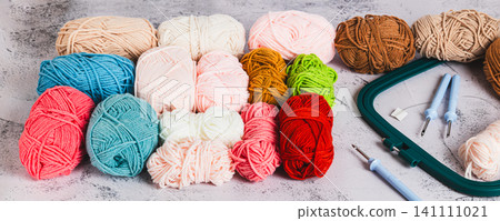 A set of colored yarn and tools for carpet embroidery on a table web banner A set of colored yarn and tools for carpet embroidery on a table web banner 141111021