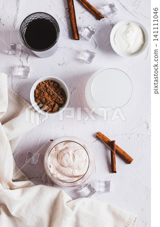 Delicious trendy protein coffee with yogurt in a glass on the table top and vertical view Delicious trendy protein coffee with yogurt in a glass on the table top and vertical view 141111046